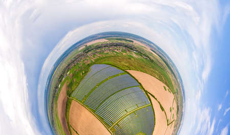 Little planet with big sustainable electric power plant with many rows of solar photovoltaic panels for producing clean ecological electrical energy. Renewable electricity with zero emission concept.の写真素材