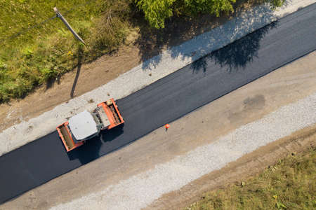 Aerial view of new road construction with steam roller machine at work.の写真素材