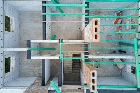 Aerial view of unfinished frame of private house with aerated lightweight concrete walls and wooden roof beams under construction.の写真素材