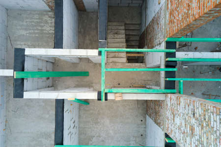 Aerial view of unfinished frame of private house with aerated lightweight concrete walls and wooden...