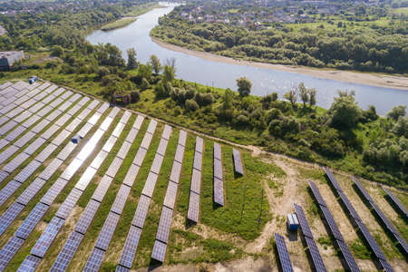 Aerial view of solar power plant on green field. Electric farm with panels for producing clean...