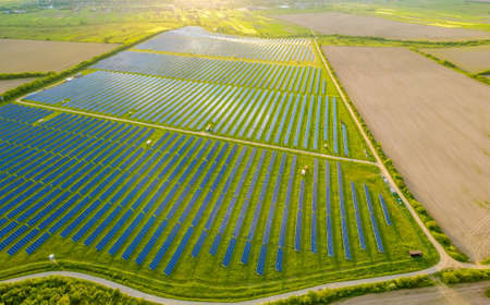 Aerial view of large sustainable electrical power plant with many rows of solar photovoltaic panels...