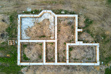 Top down aerial view of building works of new house concrete foundation on construction site.の写真素材