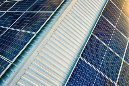 Aerial view of surface of blue photovoltaic solar panels mounted on building roof for producing...