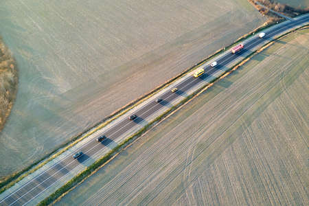 Aerial view of intercity road with fast driving cars at sunset. Top view from drone of highway traffic in eveningの写真素材