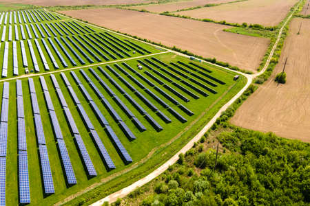 Aerial view of big sustainable electric power plant with many rows of solar photovoltaic panels for...