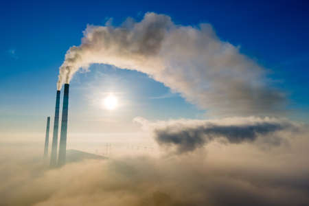Aerial view of coal power plant high pipes with black smoke moving up polluting atmosphere at sunsetの写真素材