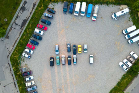Aerial view of many colorful cars parked on parking lot in eveningの写真素材