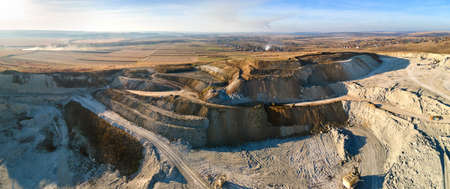 Aerial view of open pit mine of sandstone materials for construction industry with excavators and dump trucks. Heavy equipment in mining and production of useful minerals conceptの写真素材