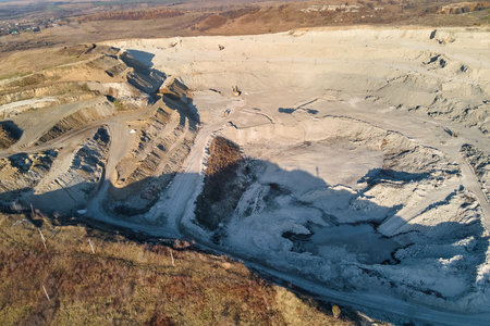 Aerial view of open pit mine of sandstone materials for construction industry with excavators and dump trucks. Heavy equipment in mining and production of useful minerals conceptの写真素材