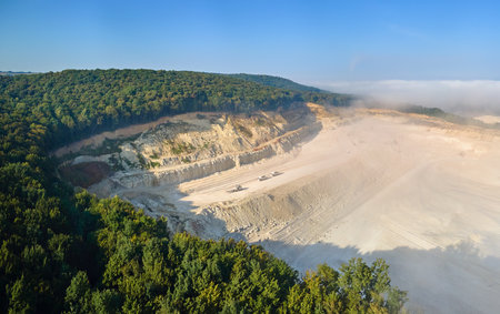 Aerial view of open pit mining site of limestone materials extraction for construction industry with excavators and dump trucksの写真素材