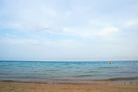 Seascape with surface of blue sea water with small ripple waves crashing on yellow sandy beach. Travel and vacations conceptの写真素材