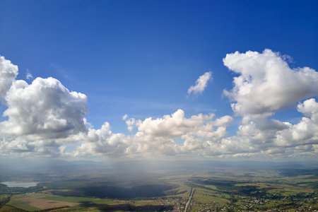 Aerial view from airplane window at high altitude of earth covered with white puffy cumulus clouds.の写真素材