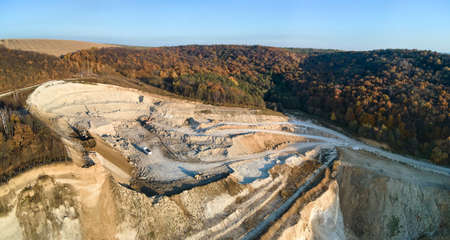 Aerial view of open pit mine of sandstone materials for construction industry with excavators and dump trucks. Heavy equipment in mining and production of useful minerals conceptの写真素材