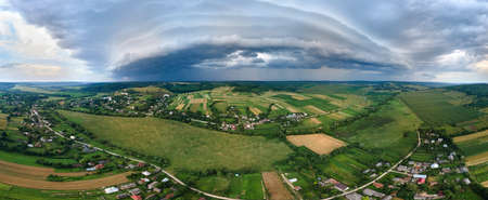 Landscape of dark clouds forming on stormy sky during thunderstorm over rural areaの写真素材