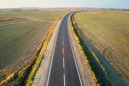 Aerial view of empty intercity road at sunset. Top view from drone of highway in evening
