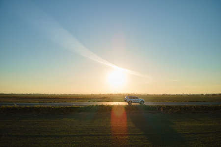 Aerial view of intercity road with blurred fast driving car at sunset. Top view from drone of highway traffic in eveningの写真素材