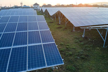 Aerial view of large sustainable electrical power plant with rows of solar photovoltaic panels for...
