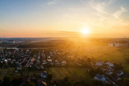 Aerial view of residential houses in suburban rural area at sunsetの写真素材
