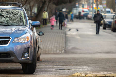 Cars parked in a row on a city street sideの写真素材
