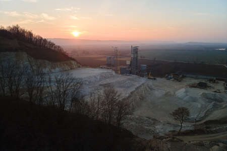 Cement factory at open pit mining of construction sand stone materials. Digging of gravel resources at quarry at sunsetの写真素材