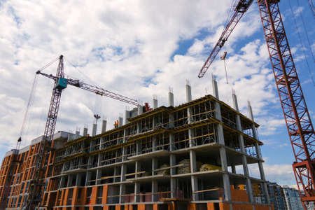 Tower crane at high concrete residential building under construction. Real estate development conceptの写真素材