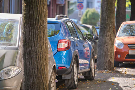 City traffic with many cars parked in line on street side