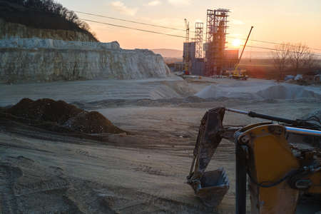 Open pit mining site of construction sand stone materials with excavator equipment for digging of...