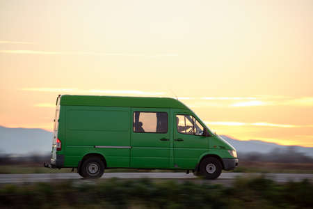 Small cargo van driving on highway hauling goods. Delivery transportation and logistics conceptの写真素材
