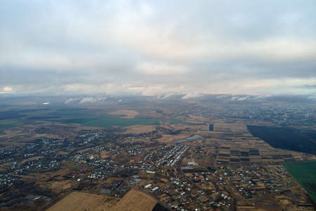 Aerial view of rural homes and distant high rise apartment buildings in city residential area during...