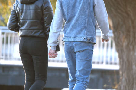 Back view of young couple walking on city street enjoying time together