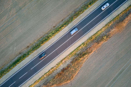 Aerial view of intercity road with fast driving cars at sunset. Top view from drone of highway traffic in eveningの写真素材
