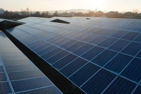 Aerial view of large sustainable electrical power plant with rows of solar photovoltaic panels for...