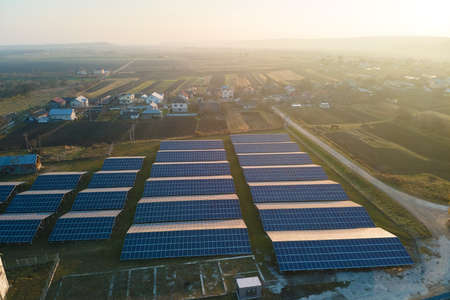 Aerial view of large sustainable electrical power plant with rows of solar photovoltaic panels for...
