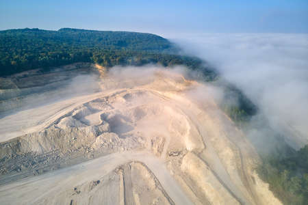 Aerial view of open pit mining of limestone materials for construction industry with excavators and...