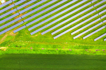 Aerial view of solar power plant on green field. Electric panels for producing clean ecologic energy
