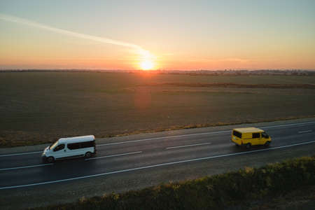 Aerial view of intercity road with fast driving cars at sunset. Top view from drone of highway traffic in eveningの写真素材