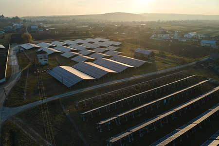 Aerial view of large sustainable electrical power plant with rows of solar photovoltaic panels for...