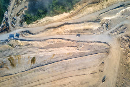Aerial view of open pit mining site of limestone materials extraction for construction industry with excavators and dump trucksの写真素材