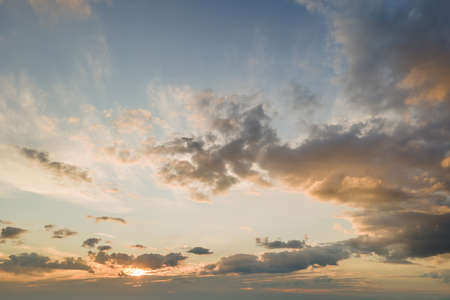 Bright colorful sunset sky with setting sun and vivid soft clouds. Concept of nature and environment