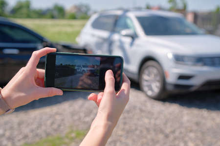 Driver hands taking photo on mobile phone camera after vehicle cの写真素材