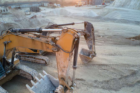 Open pit mining site of construction sand stone materials with excavator equipment for digging of...