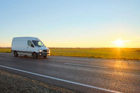 Small cargo van driving on highway hauling goods. Delivery transportation and logistics conceptの写真素材