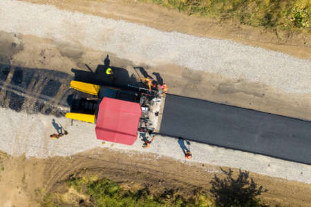 Aerial view of new road construction with asphalt laying machinery at work