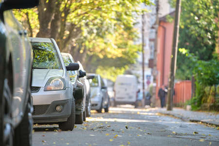 City traffic with many cars parked in line on street sideの写真素材