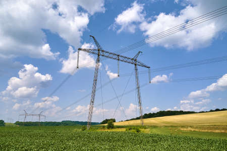 Tower with electric power lines for transfering high voltage electricity located in agricultural...