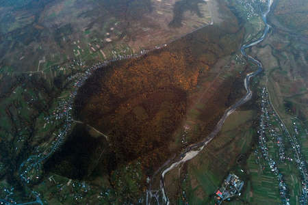 Aerial view from high altitude of distant scattered houses in rural areaの写真素材