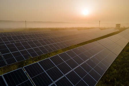 Aerial view of big sustainable electric power plant with many rows of solar photovoltaic panels for producing clean electrical energy at sunset. Renewable electricity with zero emission conceptの写真素材