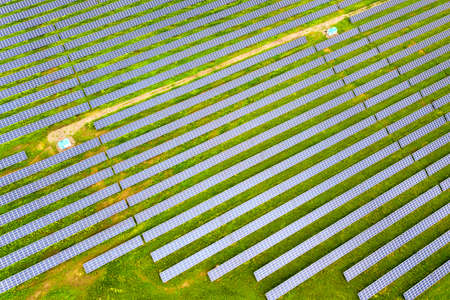 Aerial view of solar power plant on green field. Electric panels for producing clean ecologic energyの写真素材