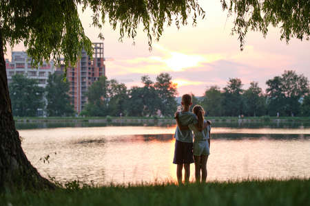 Happy siblings standing together looking at building under construction. Young children brother and sister relaxing outdoors dreaming about their future home. Family love and relationship conceptの写真素材